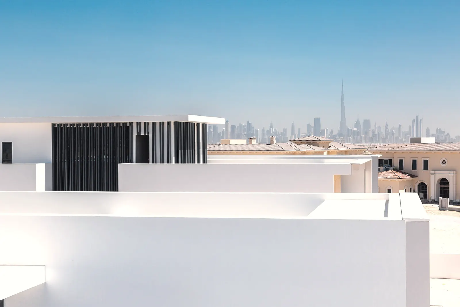 White modern architecture with the Dubai skyline in the distance